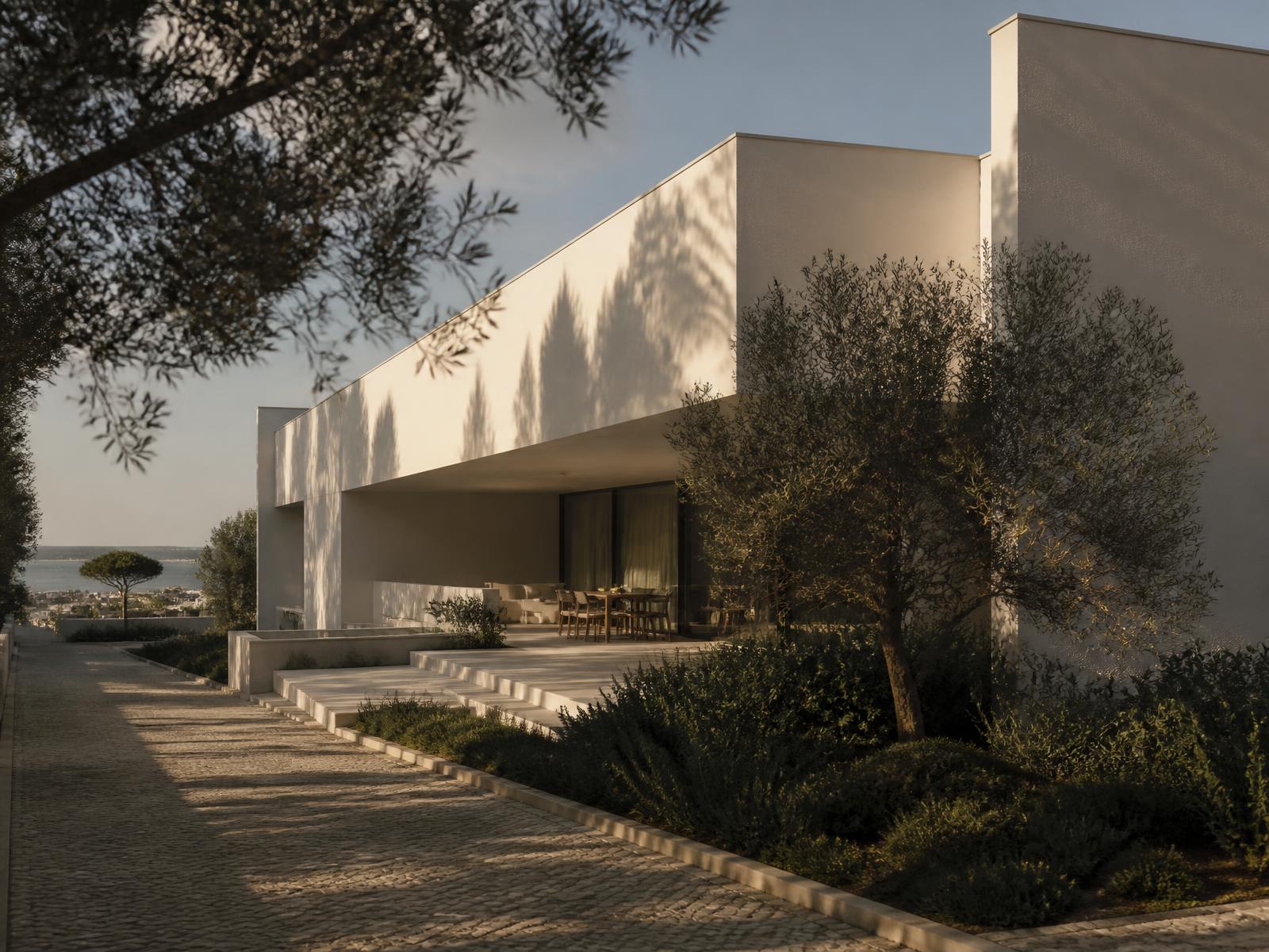 Moradia contemporânea no Restelo, volumes brancos e sombra profunda sobre o terraço